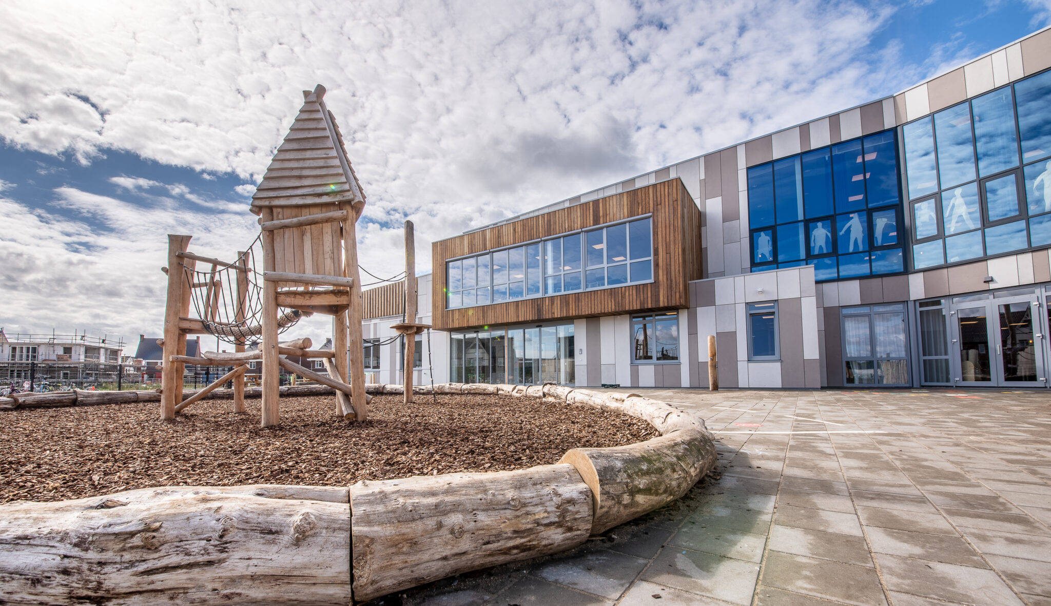 NIJMEGEN / NETHERLANDS-SEPTEMBER 13, 2019: Modern school building for children up to 12 years old. The exterior facades are sleek in design and executed in light colors. The children's playground is visible in the foreground